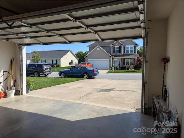 garage with a residential view and concrete driveway