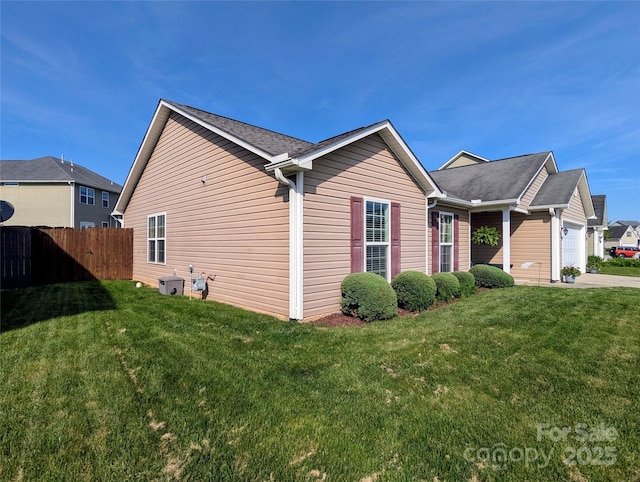 view of home's exterior with fence, a lawn, and a garage