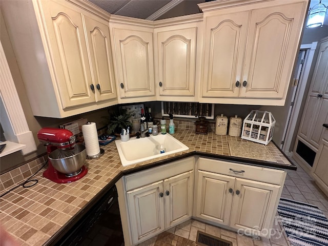 127 Hummingbird Cir, New London, NC 28127 - kitchen with tile countertops, black dishwasher, visible vents, a sink, and cream cabinets