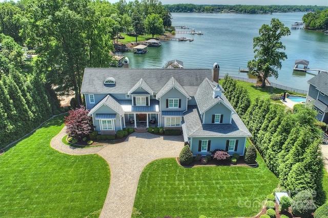 view of front facade featuring roof with shingles, a front lawn, board and batten siding, a water view, and driveway