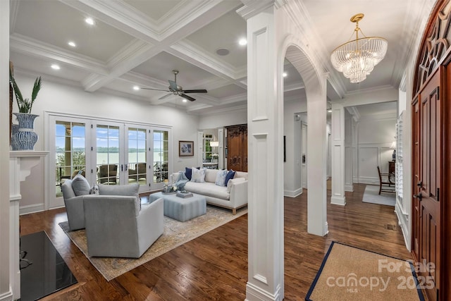 living area featuring crown molding, beam ceiling, and dark wood-type flooring