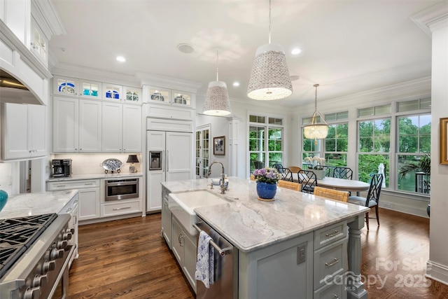 kitchen with gray cabinets, white cabinets, a sink, decorative light fixtures, and premium appliances