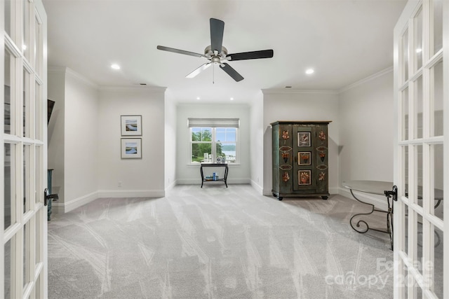 sitting room with carpet floors, a ceiling fan, ornamental molding, and french doors