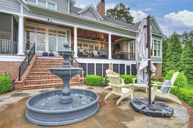 back of property with roof with shingles, stairs, a chimney, and a patio area
