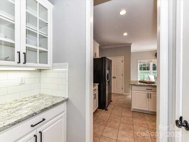 6005 Abergele Ln, Matthews, NC 28104 - kitchen with backsplash, crown molding, black fridge with ice dispenser, glass insert cabinets, and recessed lighting