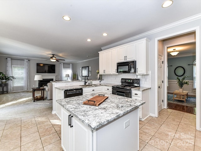 6005 Abergele Ln, Matthews, NC 28104 - kitchen with crown molding, a peninsula, ceiling fan, a sink, and black appliances
