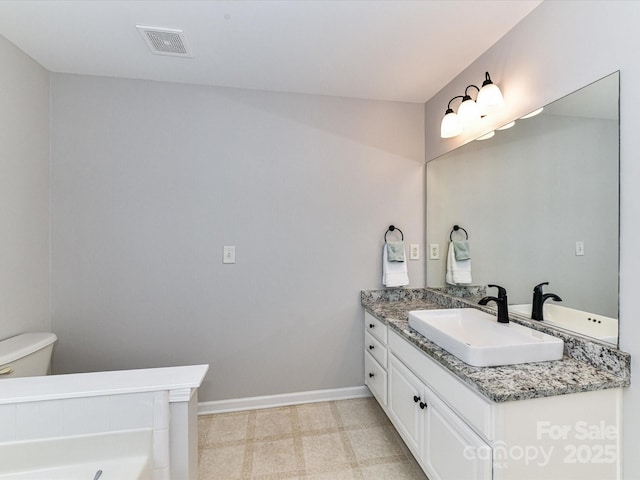 6005 Abergele Ln, Matthews, NC 28104 - bathroom featuring vanity, toilet, baseboards, a tub to relax in, and visible vents
