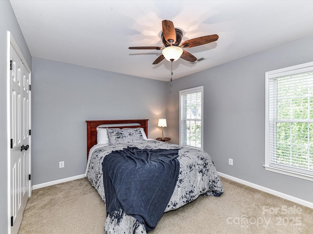 6005 Abergele Ln, Matthews, NC 28104 - bedroom featuring baseboards, a ceiling fan, light carpet, and multiple windows