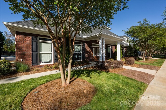 6005 Abergele Ln, Matthews, NC 28104 - view of front facade featuring brick siding, roof with shingles, and a front yard