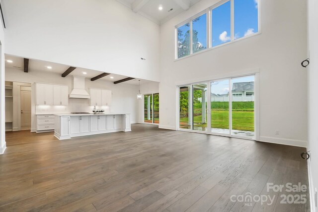 6712 Cove Ln, Sherrills Ford, NC 28673 - unfurnished living room with beamed ceiling, baseboards, dark wood-style flooring, a high ceiling, and recessed lighting