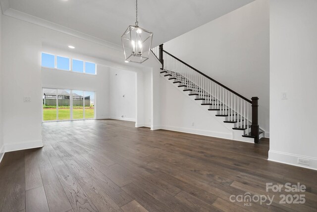 6712 Cove Ln, Sherrills Ford, NC 28673 - unfurnished living room with hardwood / wood-style flooring, stairs, baseboards, a chandelier, and a high ceiling