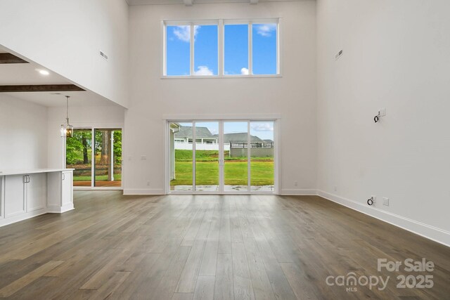 6712 Cove Ln, Sherrills Ford, NC 28673 - unfurnished living room with a towering ceiling, healthy amount of natural light, dark wood finished floors, a chandelier, and baseboards