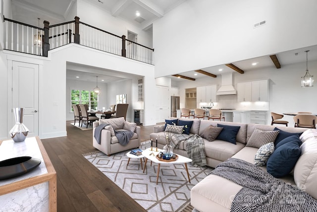 6712 Cove Ln, Sherrills Ford, NC 28673 - living room with hardwood / wood-style floors, beam ceiling, a chandelier, a towering ceiling, and baseboards