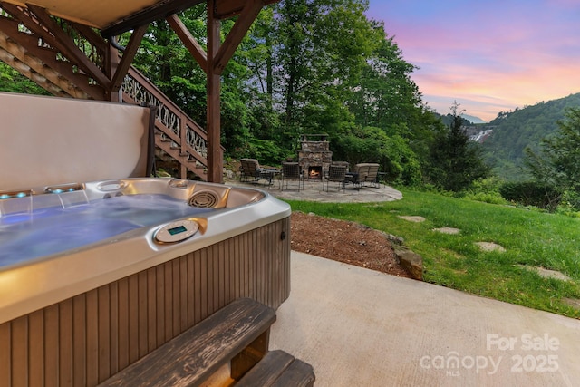 300 Falls View Dr, Lake Toxaway, NC 28774 - view of patio featuring an outdoor stone fireplace, a hot tub, stairway, and a mountain view