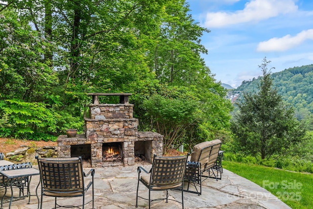300 Falls View Dr, Lake Toxaway, NC 28774 - view of patio / terrace featuring an outdoor stone fireplace and a mountain view