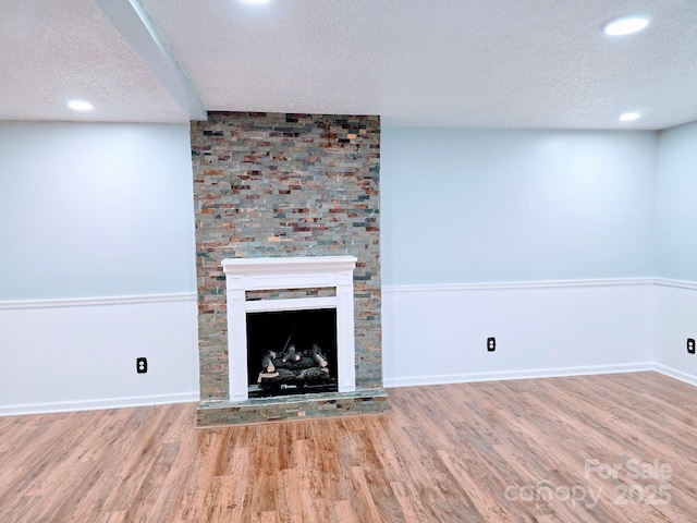 unfurnished living room with recessed lighting, wood finished floors, and a textured ceiling