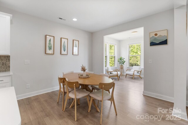 dining space featuring light wood finished floors, recessed lighting, visible vents, and baseboards