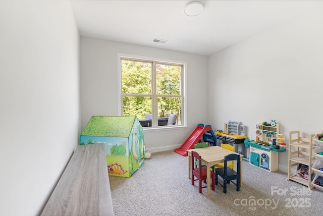 rec room with carpet, visible vents, and baseboards