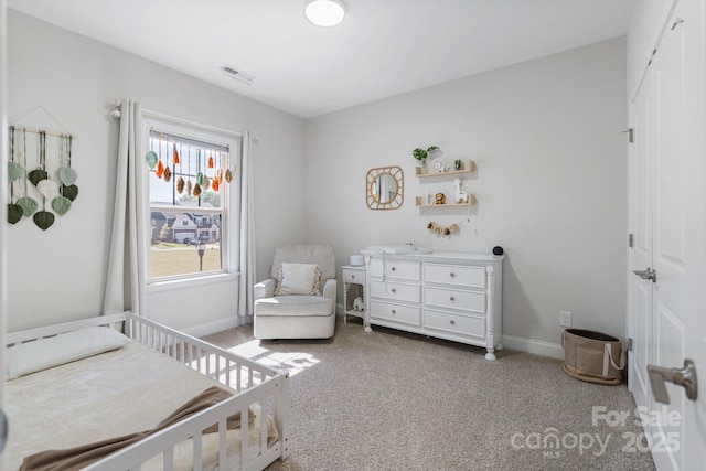 carpeted bedroom featuring a closet, visible vents, and baseboards