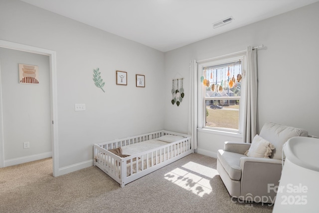 bedroom featuring a crib, visible vents, carpet, and baseboards
