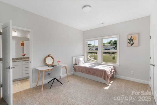 bedroom featuring light colored carpet, visible vents, ensuite bath, and baseboards