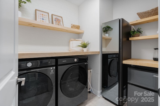 laundry room with light tile patterned floors, laundry area, and washing machine and dryer