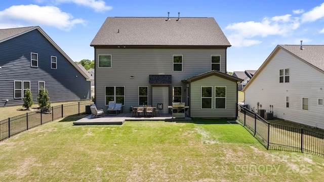 rear view of property with a lawn, a deck, and a fenced backyard