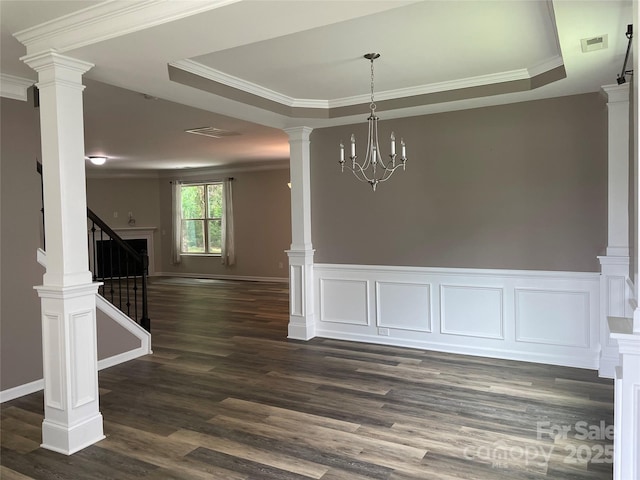 unfurnished dining area featuring dark wood-style flooring, visible vents, a tray ceiling, and ornamental molding