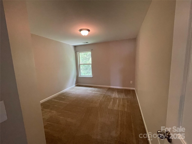 empty room featuring baseboards and carpet