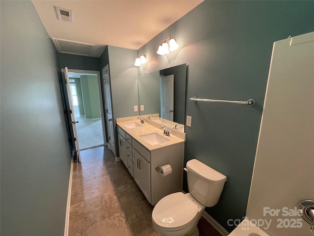 full bath with visible vents, toilet, double vanity, and a sink