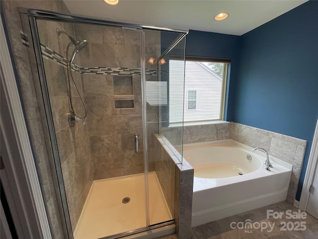 bathroom featuring recessed lighting, a bath, and a stall shower