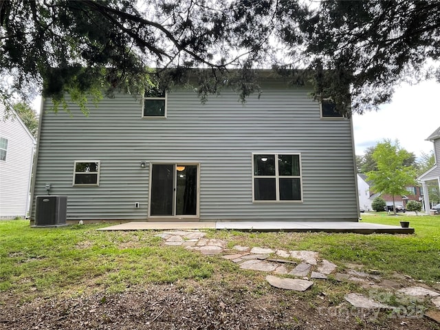 rear view of house with a lawn, a patio area, and central AC