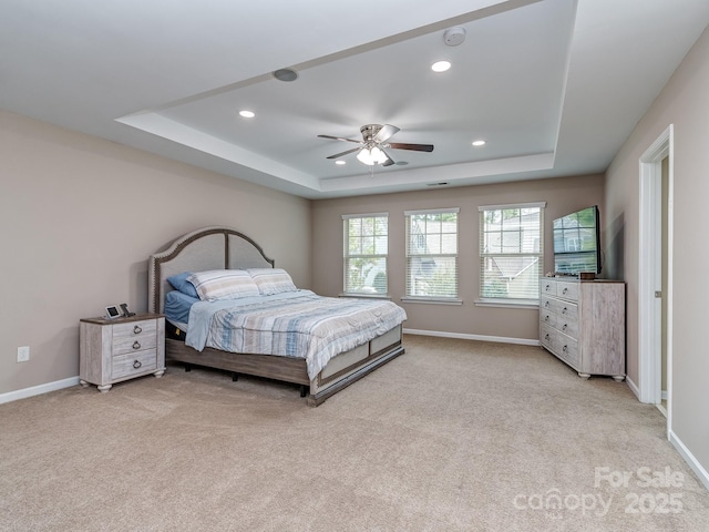 bedroom featuring recessed lighting, a raised ceiling, baseboards, and light carpet