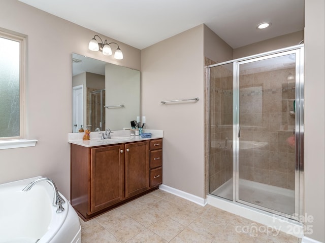 bathroom featuring tile patterned flooring, vanity, baseboards, a garden tub, and a stall shower