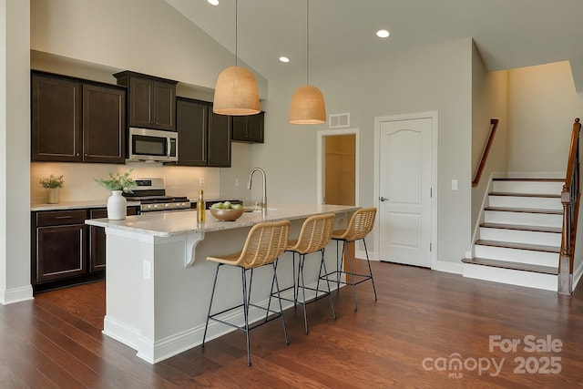 4926 Trayton Ave, Gastonia, NC 28056 - kitchen featuring a kitchen breakfast bar, visible vents, a sink, stainless steel appliances, and dark wood-type flooring