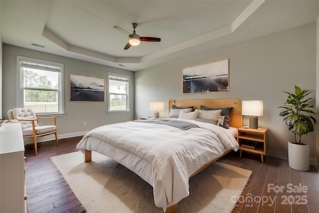 4926 Trayton Ave, Gastonia, NC 28056 - bedroom featuring ceiling fan, visible vents, wood finished floors, baseboards, and a tray ceiling