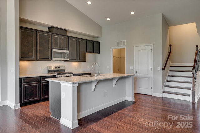4926 Trayton Ave, Gastonia, NC 28056 - kitchen featuring an island with sink, dark wood-style floors, high vaulted ceiling, a sink, and stainless steel appliances