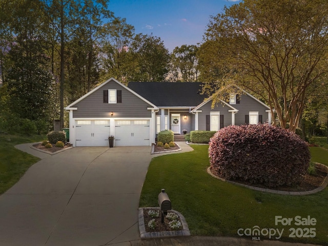 view of front of house with a garage, driveway, and a front lawn