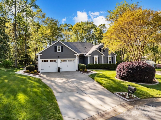 view of front of property featuring an attached garage, driveway, and a front yard
