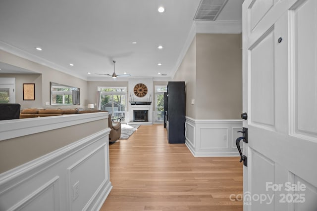 hall featuring visible vents, recessed lighting, light wood-style flooring, and crown molding