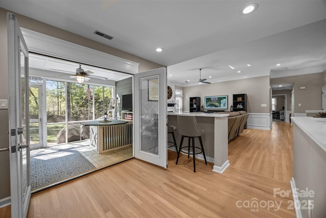 kitchen featuring light wood-style floors, open floor plan, ceiling fan, and french doors