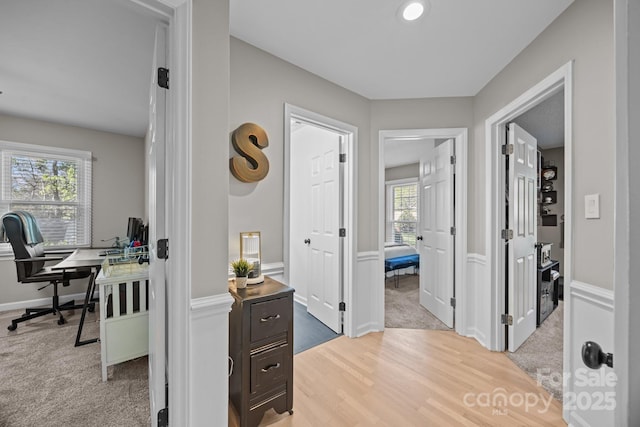 corridor with recessed lighting, baseboards, light carpet, and light wood-type flooring