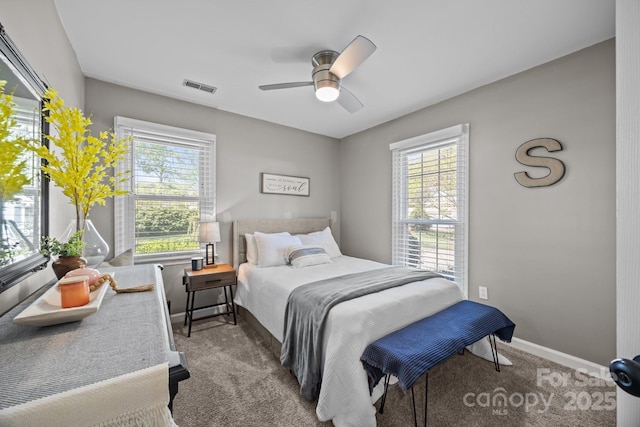 bedroom featuring carpet floors, baseboards, visible vents, and multiple windows
