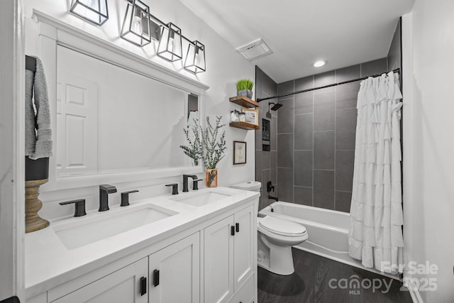 bathroom featuring shower / bath combo with shower curtain, toilet, a sink, and wood finished floors