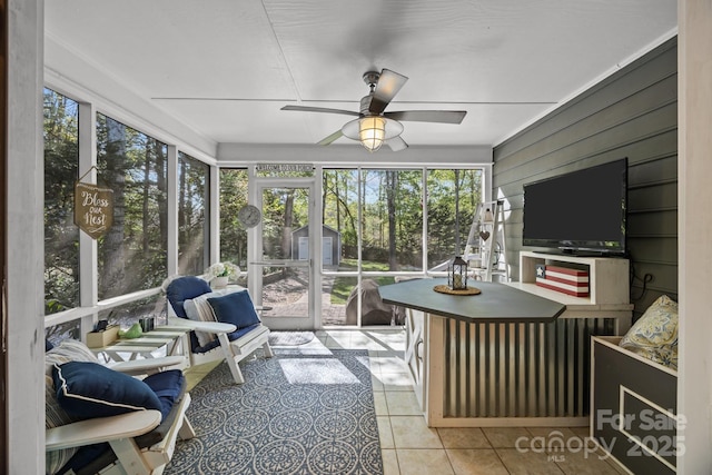sunroom / solarium featuring ceiling fan