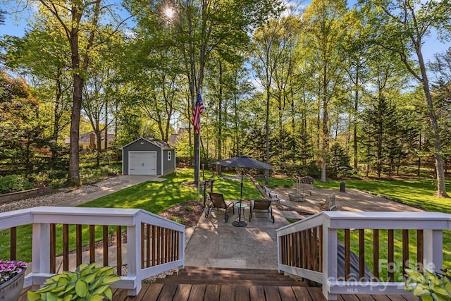 deck with a garage, a patio area, a lawn, an outdoor structure, and driveway