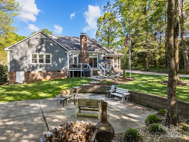 back of property with a lawn, crawl space, a patio area, and a deck