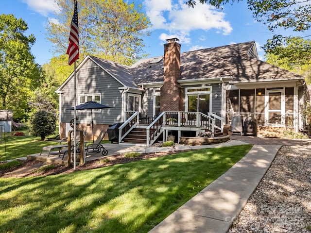 view of front facade featuring a front lawn, a wooden deck, a sunroom, a chimney, and a patio