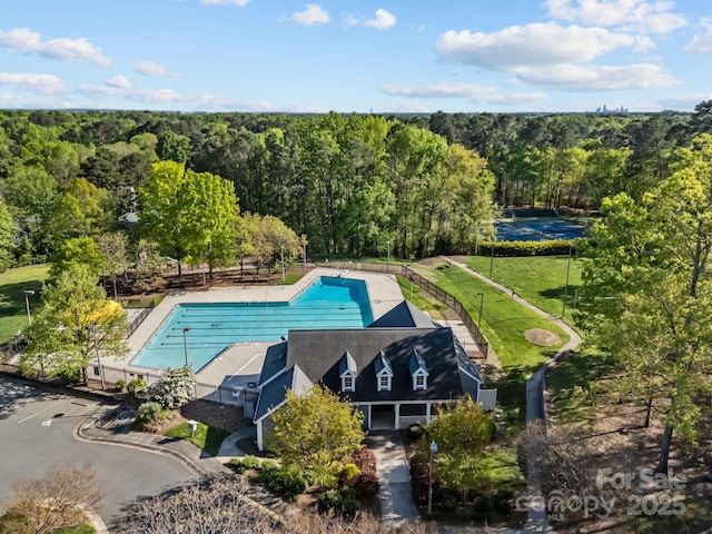 view of pool with a fenced in pool and a forest view