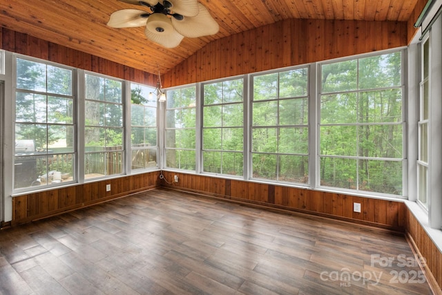 unfurnished sunroom featuring a wealth of natural light, wood walls, wood finished floors, and vaulted ceiling